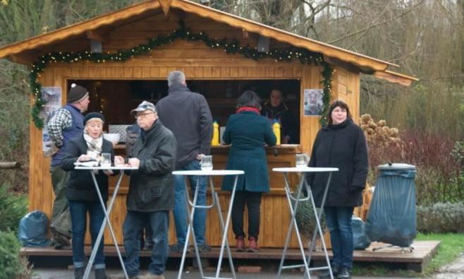 Mehrere Personen stehen vor einem Stand, an dem Glühwein angeboten wird